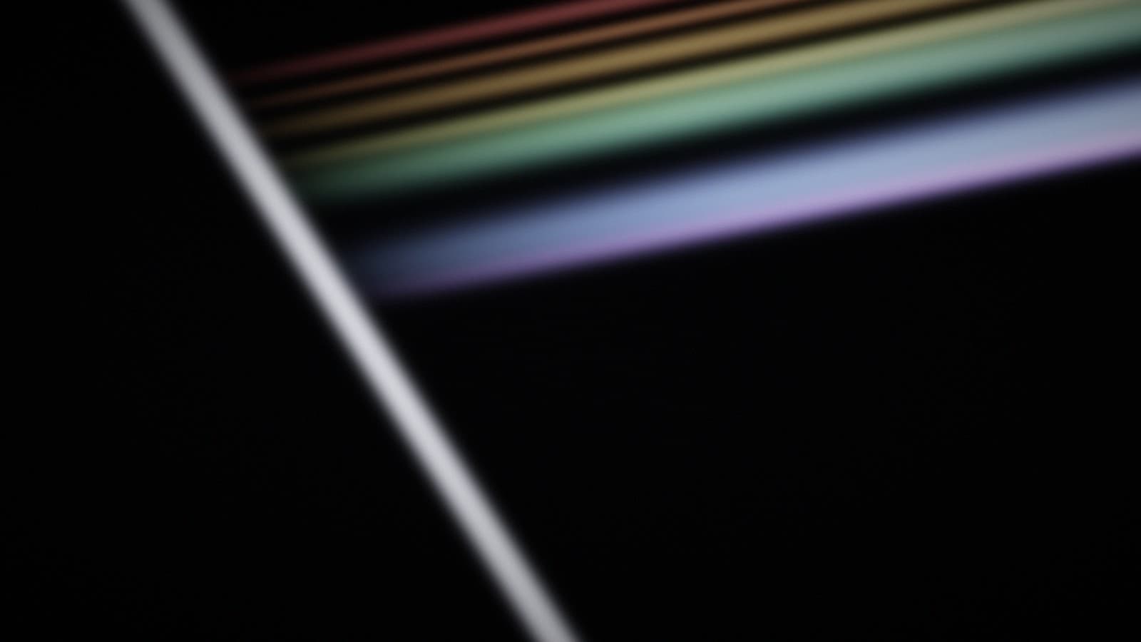 A narrow beam entering glass at an angle and leaving it as separated colour.